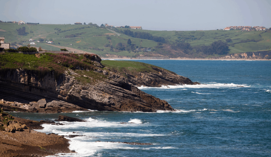 Stunning Cantabrian coastal landscape with rolling green hills and dramatic cliffs along ocean