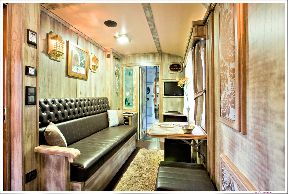 Luxurious train compartment interior with leather seating, wood paneling and elegant amenities aboard El Transcantábrico